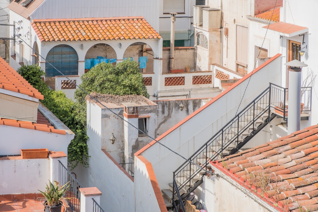 person taking photo of white and orange concrete building, Poble