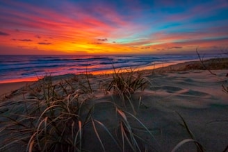 A vibrant sunset casting colors over the beach and water.
