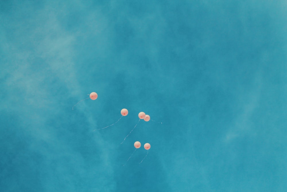 low angle view of six orange balloons during blue sky
