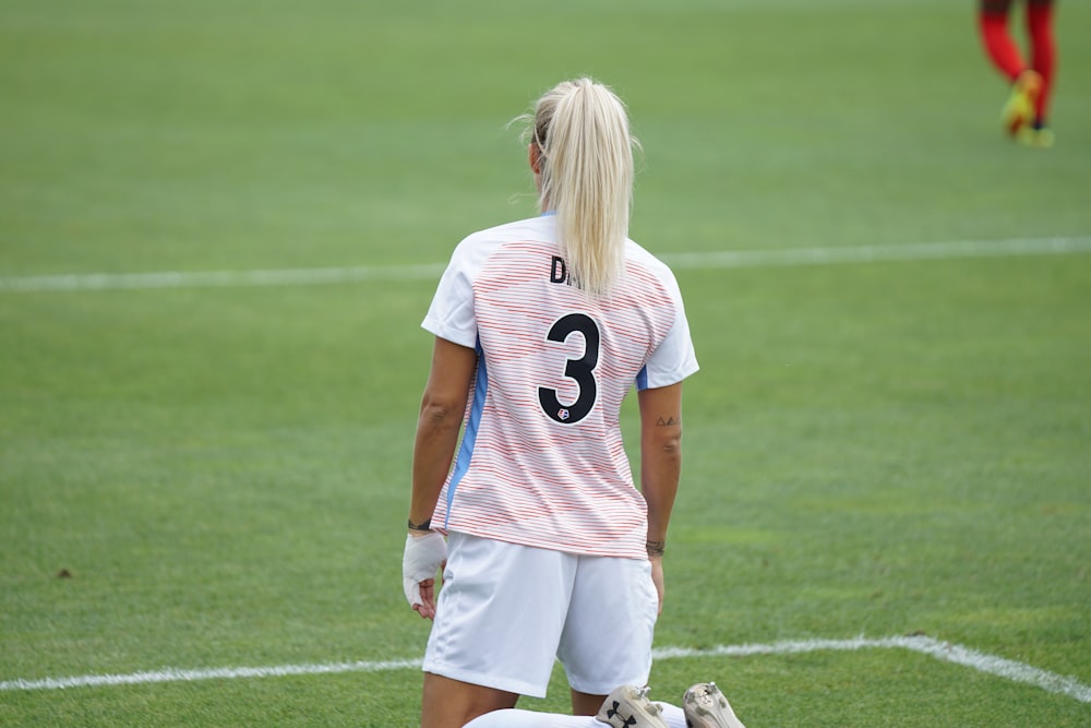 female soccer player standing at field