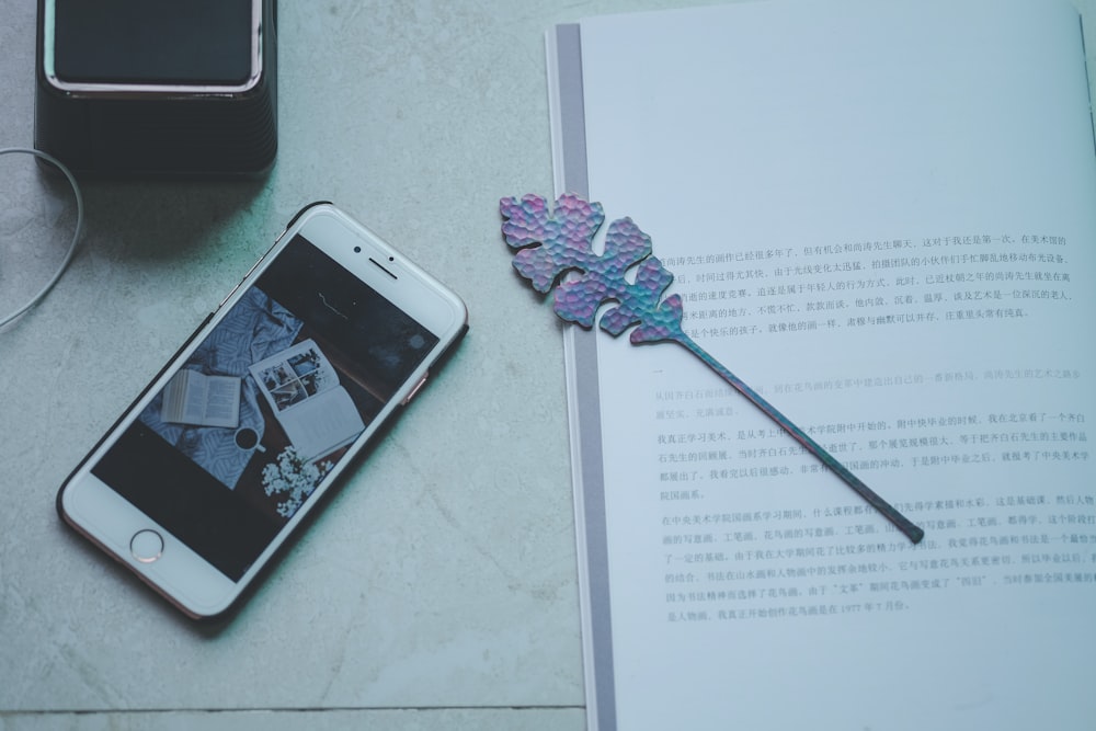 silver iPhone 6 beside leaf bookmark