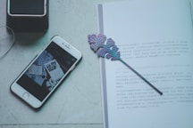 silver iPhone 6 beside leaf bookmark