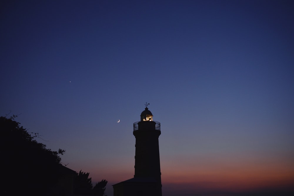 silhouette of lighthouse during nighttime