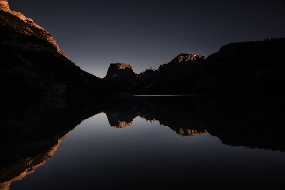 landscape of mountains beside the body of water