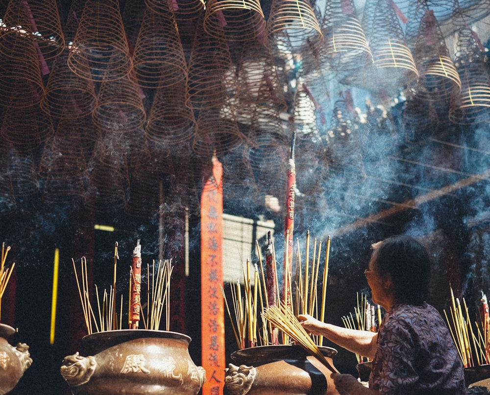 woman holding brown incense sticks