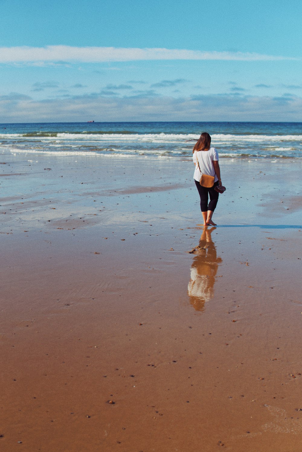 donna che cammina sulla spiaggia