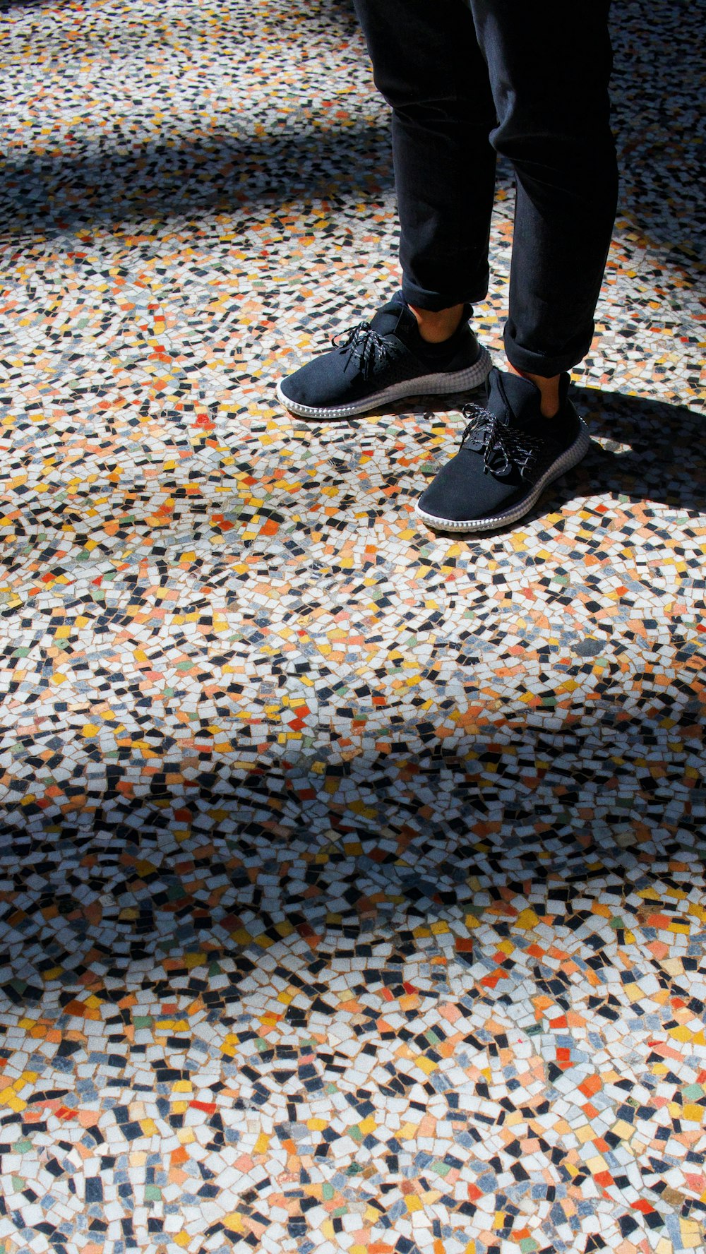person standing on multicolored tiles