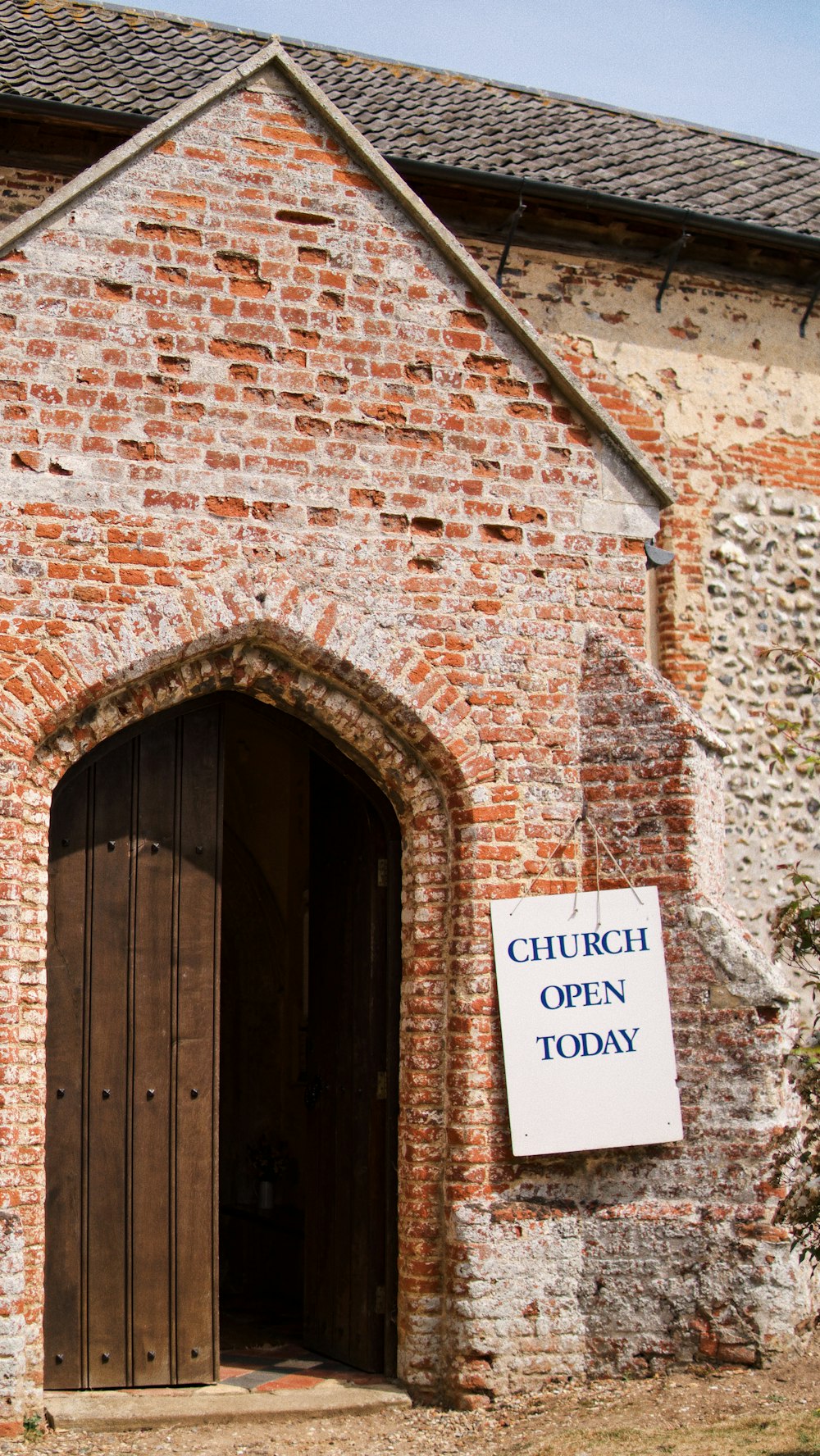 LETRERO DE IGLESIA ABIERTA HOY QUE CUELGA EN LA IGLESIA DE LADRILLO