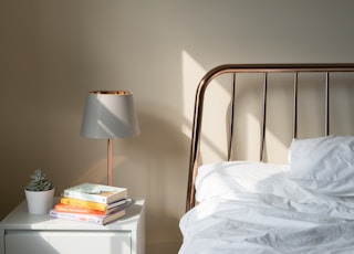 table lamp on white wooden nightstand beside bed