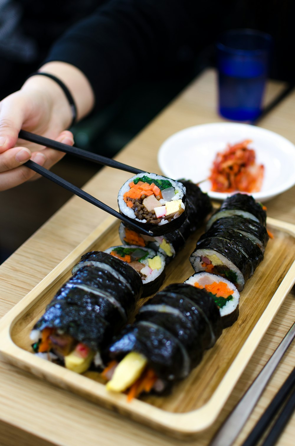 pessoa escolhendo sushi usando pauzinhos