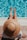 woman sitting on poolside setting both of her feet on pool