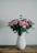 Elegant flower arrangement displayed in a modern vase on a wooden table.