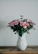 Elegant flower arrangement displayed in a modern vase on a wooden table.