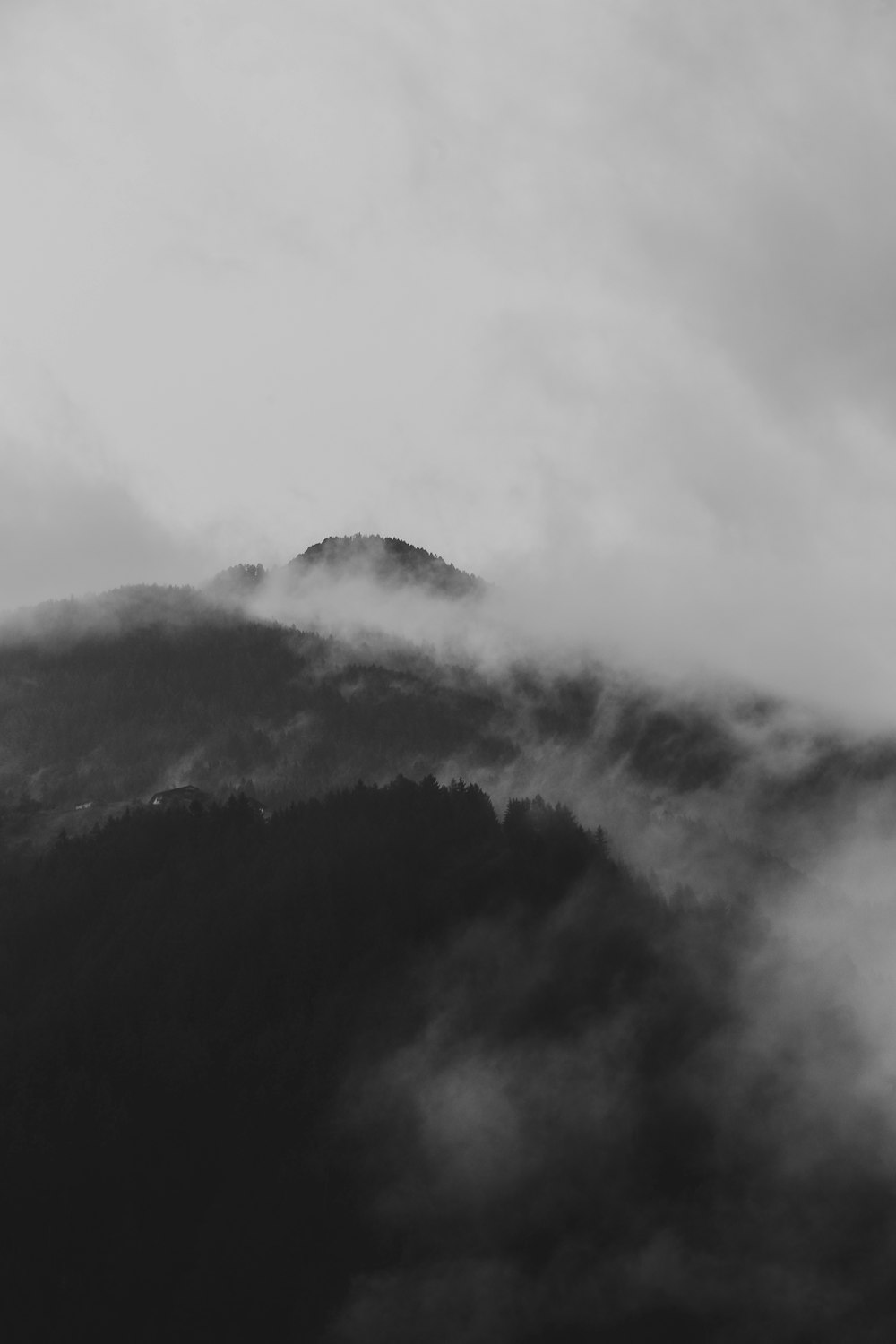 구름이 있는 산의 회색조 사진