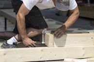 Член на екипа на Hedgie Wilder монтира дървени подпори за нова градинска тераса в дом в Пловдив.