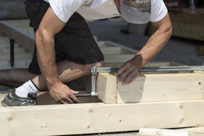 man holding gray metal hand tool