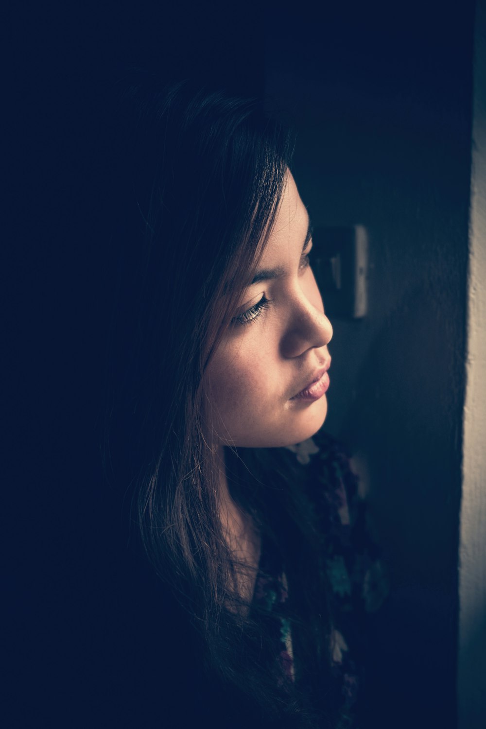 selective focus photography of woman standing beside white wall