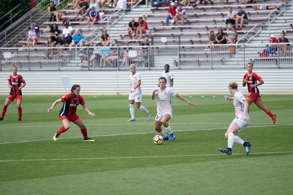 two soccer teams playing on ground at daytime