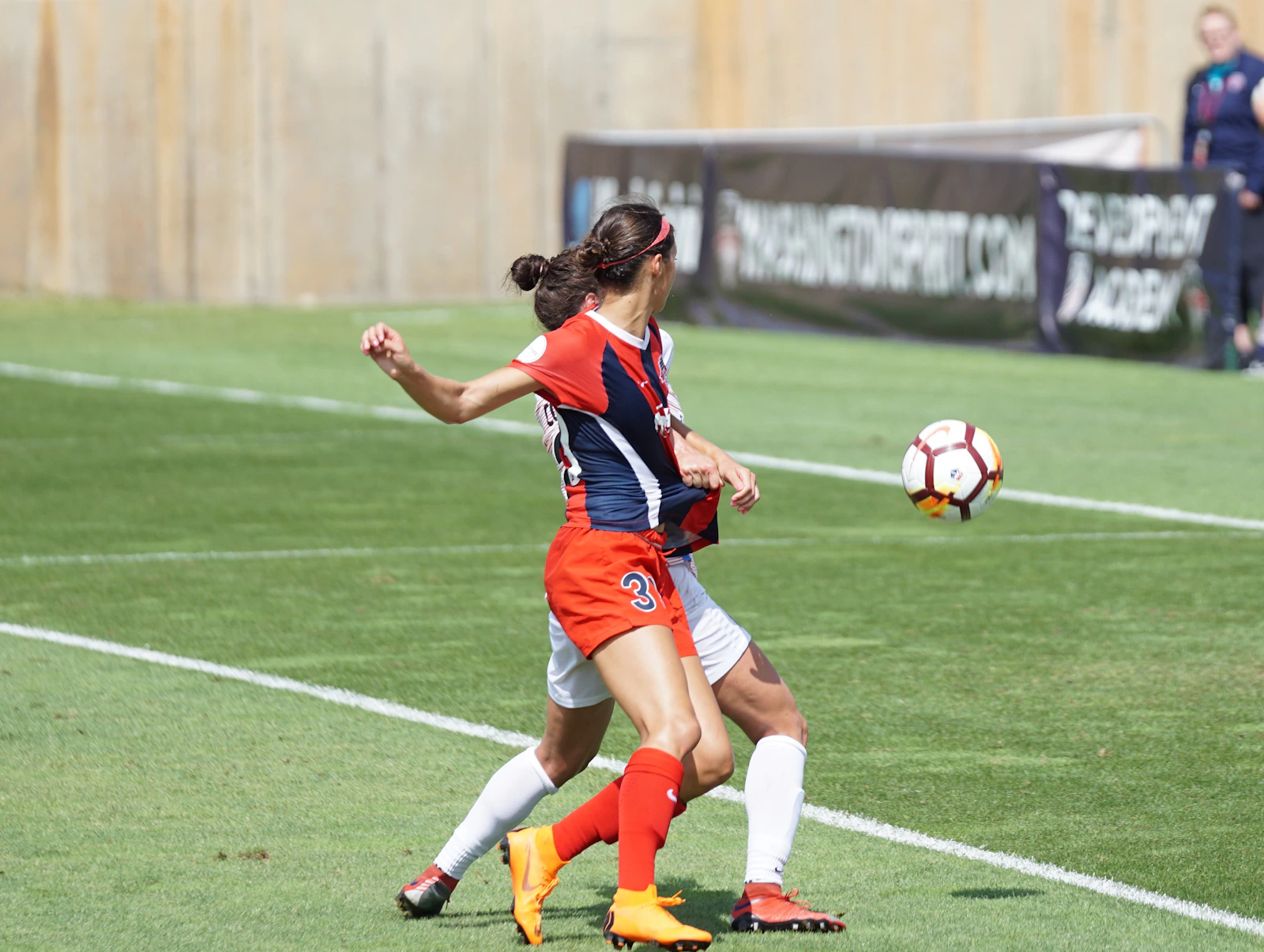 Women soccer players competing for the ball on the pitch — fierce action