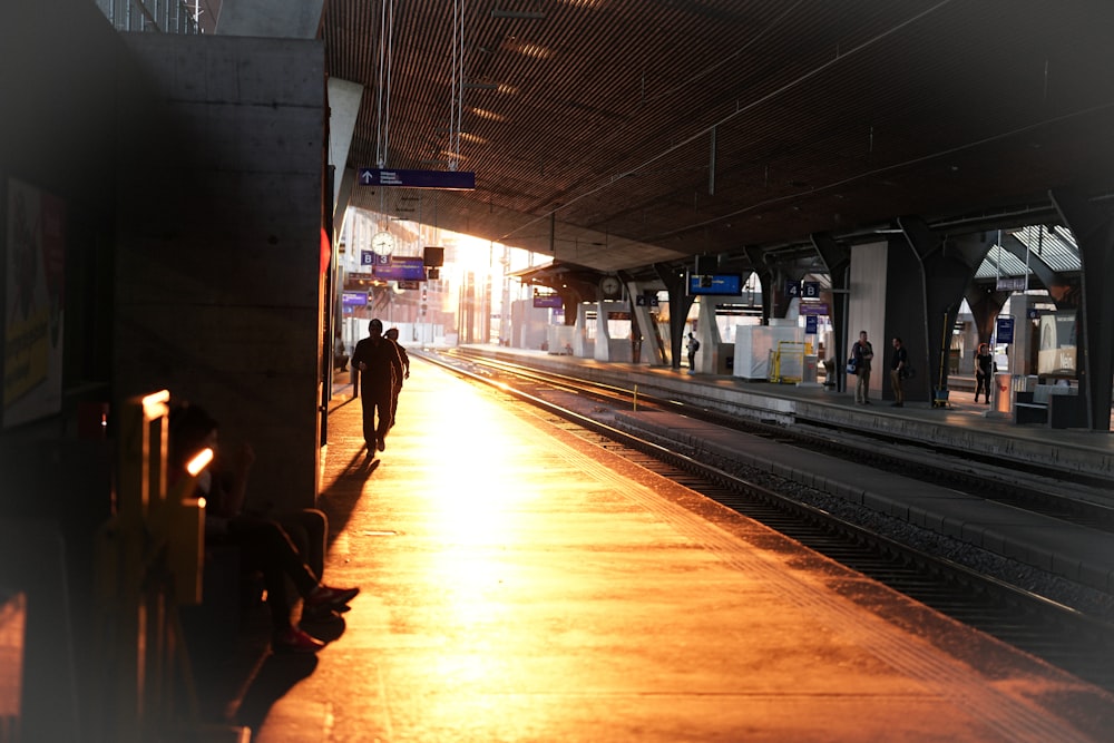 silhouette of person standing beside railway