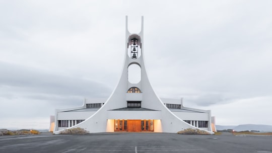 white concrete building under white clouds in Stykkishólmur Iceland