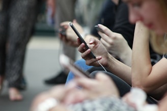 A diverse group of people smiling and chatting on their phones, representing global connection through audio.