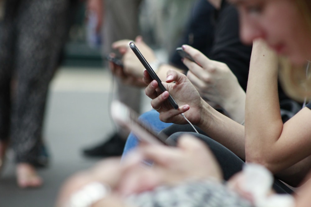 Persona sosteniendo un teléfono negro