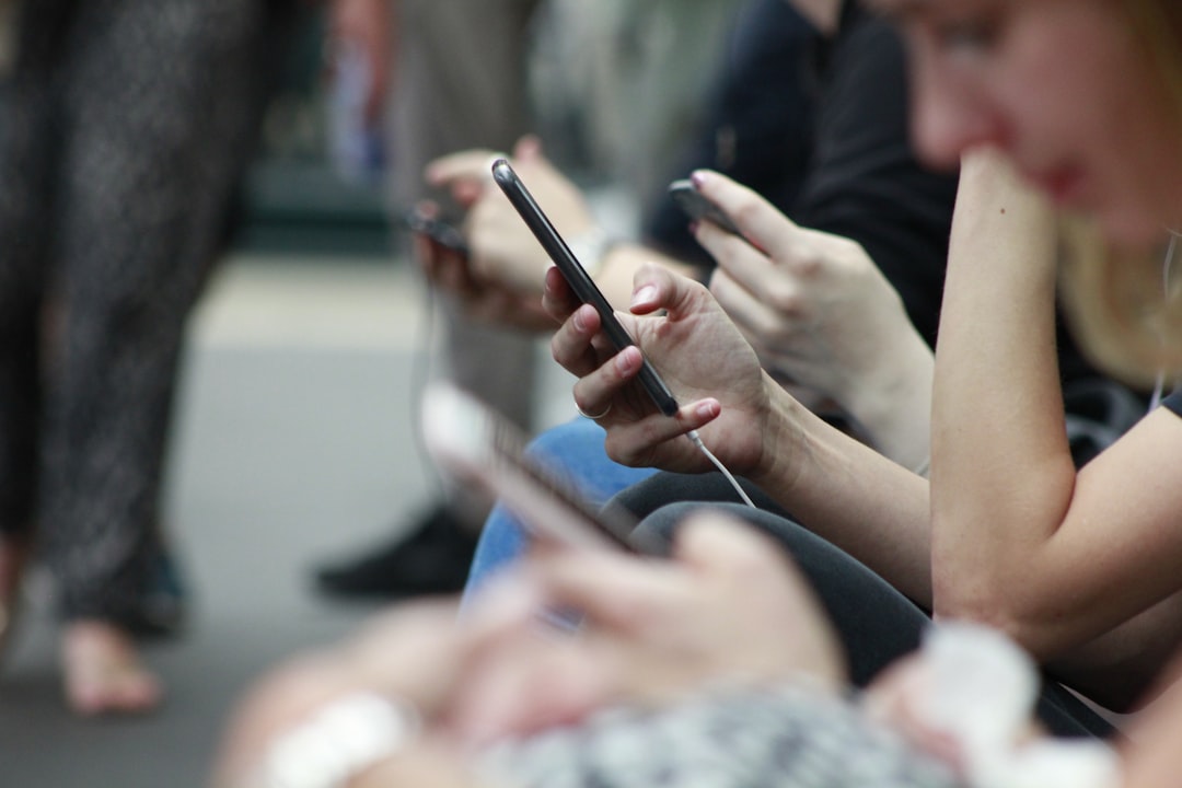 person holding black phone, I heard recently that the average person scrolls the height of Big Ben in a day. Whilst wait