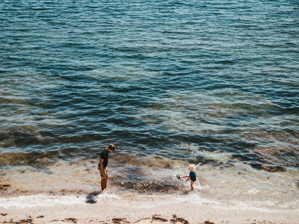 man and child on seashore