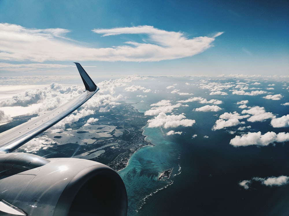 photo of airplane wing under blue sky at daytime