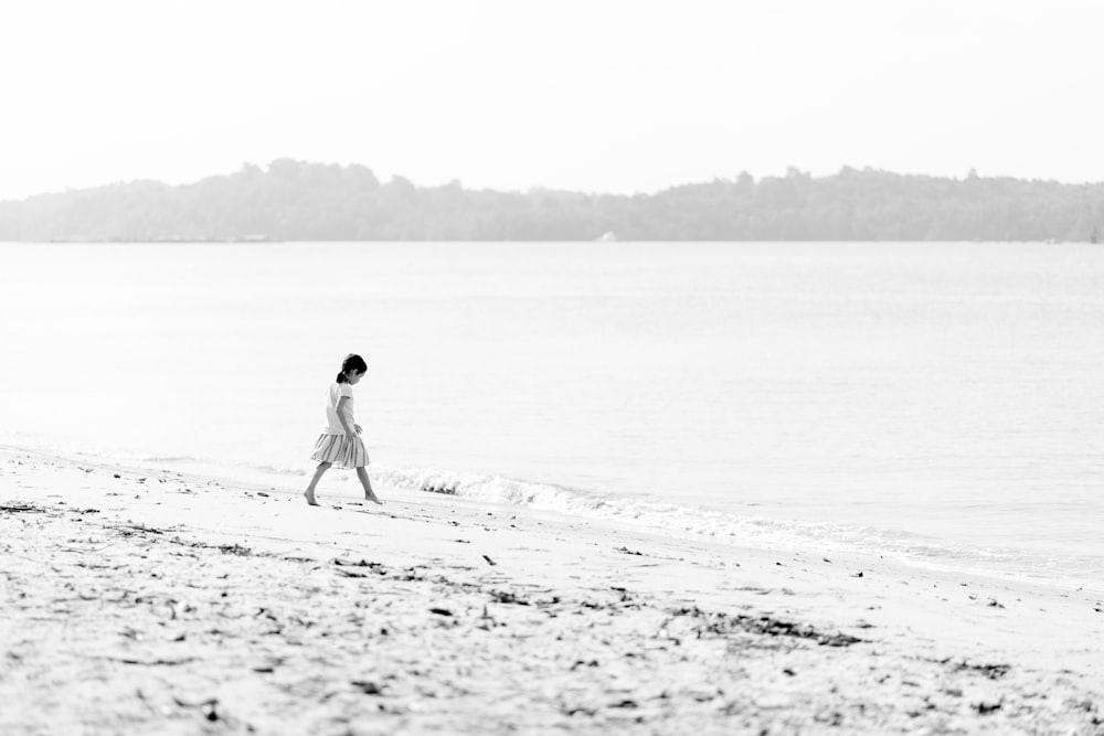girl walking on beach during day time