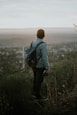 man carrying grey leather backpack