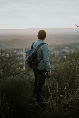 man carrying grey leather backpack