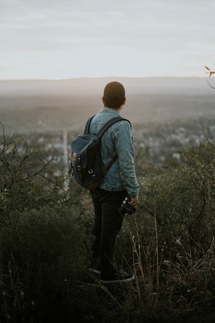 man carrying grey leather backpack
