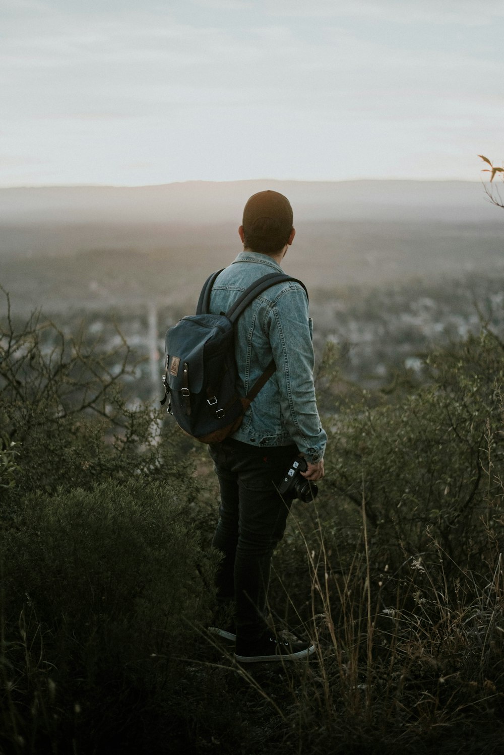 man carrying grey leather backpack