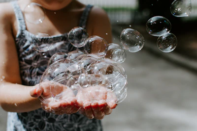 Colorful illustration of a child experimenting with bubbles and light beams.