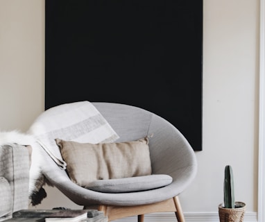 round grey moon chair with brown pillow on top