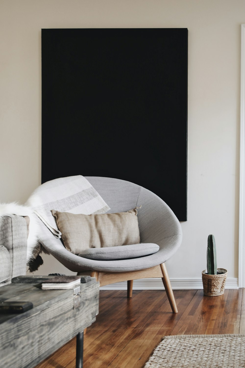 round grey moon chair with brown pillow on top