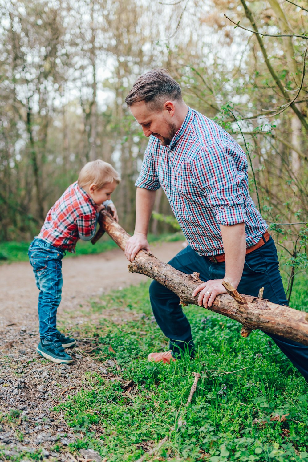 man holding tree branch in front of boy