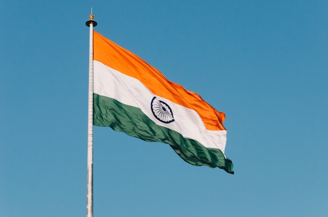 Indian national flag waving against a blue sky, symbolizing the National Overseas Scholarship Scheme