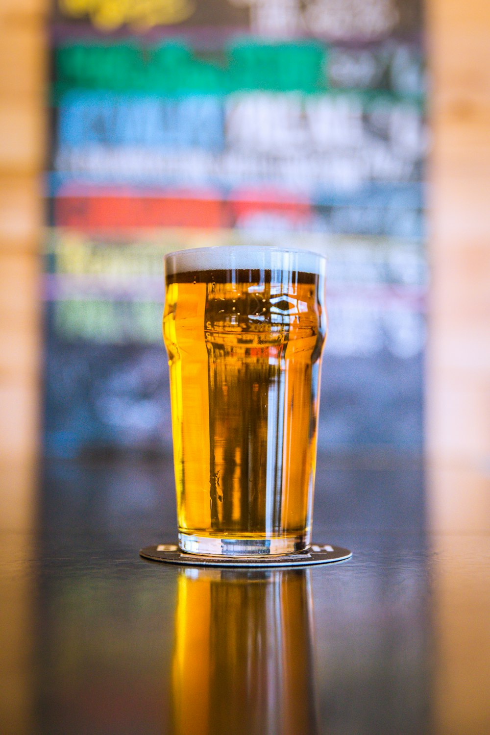 Fotografía de enfoque superficial de vidrio de cerveza transparente