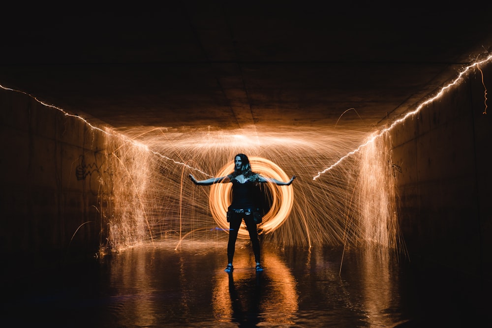 standing woman with background of long exposure photo of orange light