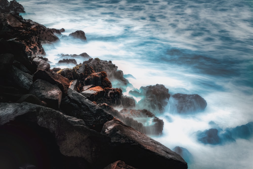 body of water smashing trough rocks