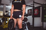 woman holding black weight plate