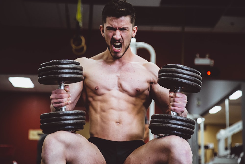 man holding two dumbbells