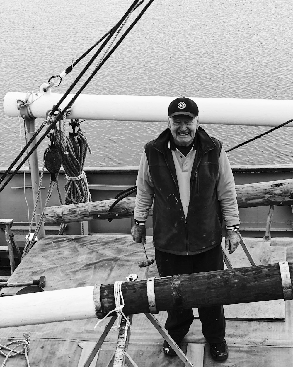 grayscale photography of man standing near body of water