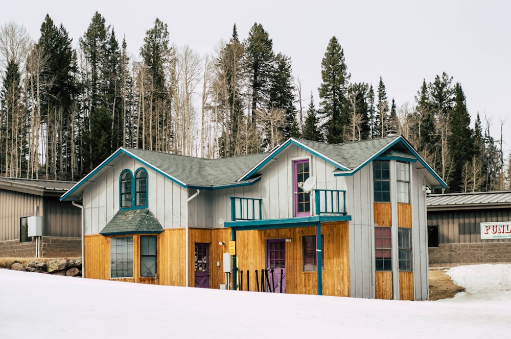 Maison en bois blanc et jaune près des arbres