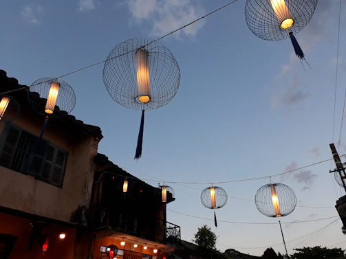 Evening lanterns casting warm light over the rooftop terrace framed by archways.