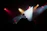 A cheerful young girl confidently speaking on stage with colorful lights behind her.