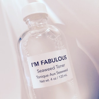 A close-up view of a transparent bottle with a white cap, labeled I’M FABULOUS Seaweed Toner. The bottle appears to contain a clear liquid, and the label also states that the toner is seaweed-based and has a net weight of 4 oz / 120 mL.